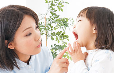 子どもの歯をチェックする親